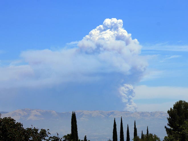The Powerhouse Fire burning in the Angeles National Forest northwest of Los Angeles sends up a huge plume of smoke on Saturday, June 1, 2013. Smoke from the fire made visibility hazy in the San Fernando Valley, foreground. The blaze has erupted in size since Thursday afternoon when it started near a utility powerhouse.