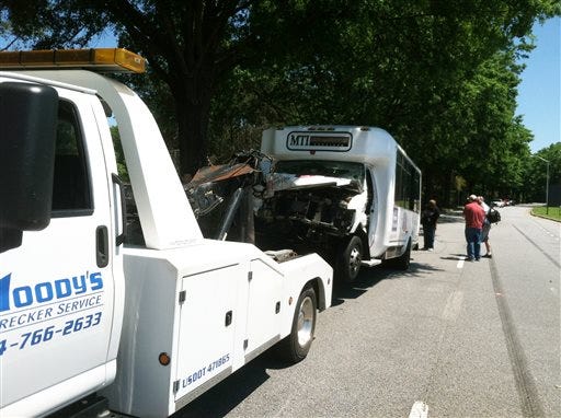 A hotel shuttle bus is readied to towing after it crashed with a tractor-trailer on the road that loops around Hartsfield-Jackson Atlanta International Airport, in College Park, Ga., on Friday, May 24, 2013. All 16 people in the crash were taken to area hospitals. None of the injuries are believed to be life-threatening, said Sgt. Keith Stanley. It appears the shuttle struck the side of a tractor-trailer that was attempting a U-turn on the divided road, said Sgt. Stanley. (AP Photo/Ray Henry)