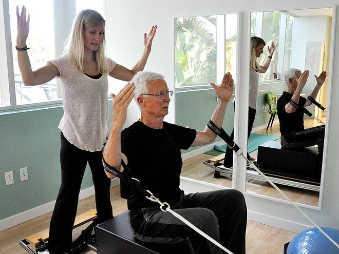 Ashley Brooks helps client Jim Anderson work on a machine to improve posture and strengthen his back during a recent session at Holistic Movements Pilates and Barre Studio in Port Orange.
