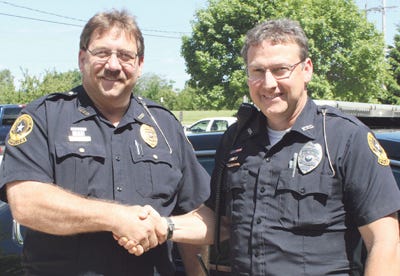 Police Chief Jim Dison, left, congratulates Lee Monroe on his retirement.