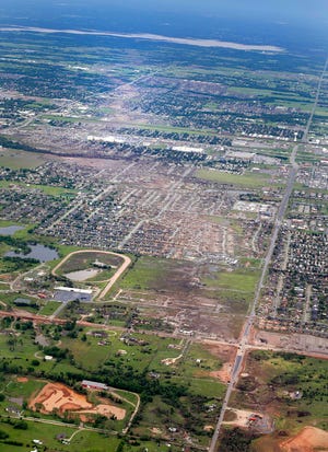 File - This May 21, 2013 file aerial photo shows the remains of houses in Moore, Okla., following a tornado the May 20, 2013 tornado. The Oklahoma City area has seen two of the extremely rare EF5 tornadoes in only 11 days. The tornado that hit El Reno had a record-breaking width of 2.6 miles. The one in Moore, a city about 25 miles away from El Reno, killed 24 people and caused widespread damage. (AP Photo/Kim Johnson Flodin, File)