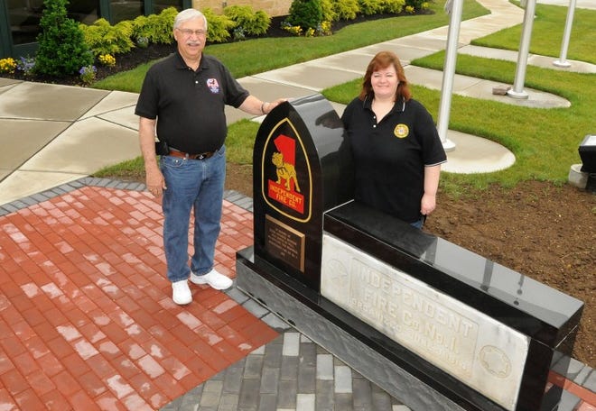 Bob Ciasca, retired fire marshall, and Christine Warren, pose outside of Independent Fire Co. No. 1 in Burlington Township on Monday morning with a new memorial that was created to honor volunteer firefighters.