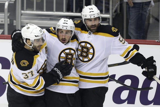 Boston Bruins' Brad Marchand, center, celebrates his goal with teammates Patrice Bergeron, left, and Johnny Boychuk in the first period of Game 2 of the NHL Stanley Cup playoffs Eastern Conference finals against the Pittsburgh Penguins in Pittsburgh on Monday, June 3, 2013. The Bruins won 6-1.