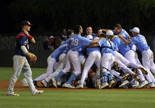 North Carolina celebrates its 12-11 win over Florida Atlantic in 13 innings during an NCAA college regional championship baseball game in Chapel Hill early Tuesday morning as Florida Atlantic's Brendon Sanger, left, walks off the field. (AP Photo/Ted Richardson)