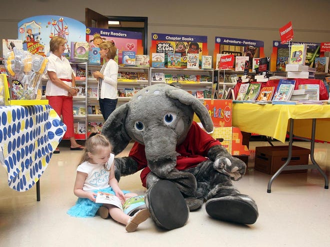 Ella Perkins, 4, reads a book with Big AL during a book fair at the Tuscaloosa Public Library on July 20, 2011.