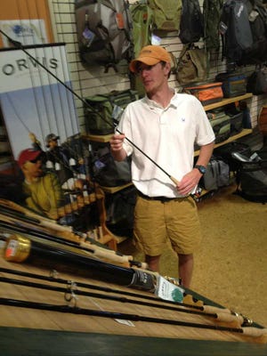 Davis McDougal, an employee at Rivers and Glen Trading Co. in Augusta, shows some of the flex fly fishing rods the business sells. Rivers and Glen says it is seeing more young men visiting the store to tie flies and buy gear to fish in local ponds and creeks.