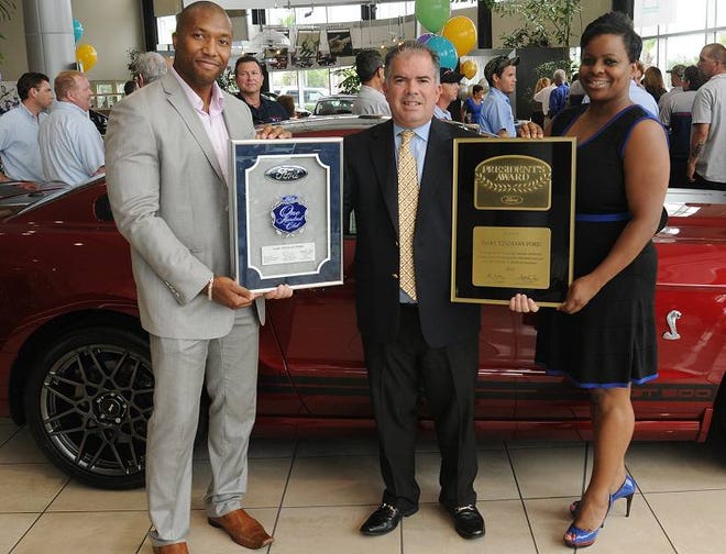 Joel Sinclair, left, presents Gary Yeomans Ford Dealer/General Manager Carlos Lira, center, with the One Hundred Club award and Chaun Avery presents the President’s Award at dealership in Daytona Beach on Wednesday.