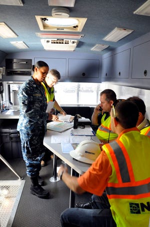 As part of the Hurricane Exercise (HURREX) conducted the third week of May in Navy Region Southeast, Naval Facilities Engineering Command (NAVFAC) Southeast deployed a Contingency Engineering Response Team (CERT) May 22 to Naval Station Mayport to practice their skills. Public Works Department Mayport Production Officer Lt. Cheron Thornton (left) briefs the CERT in the mobile command post (MCP) on simulated damaged buildings (as a simulated hurricane heads for Pensacola) that will require assessment by the Damage Assessment Teams (DATs). The CERT completed the exercise and is ready for the 2013 hurricane season learning valuable lessons from the HURREX.