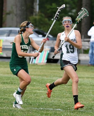 Marshfield defender Jessie Spitz, right, brings the ball up against Bishop Feehan Wednesday, May 29, 2013, during the first-round game of the Division 1 South Sectional lacrosse tournament.