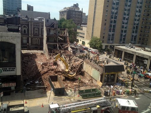 Emergency personnel respond to a building collapse in downtown Philadelphia, where the city fire commissioner says as many as eight to 10 people are believed trapped in the rubble, Wednesday, June 5, 2013. (AP Photo/Dino Hazell)