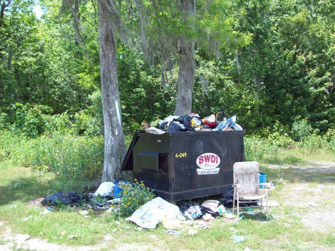 A dumpster near the LaRousse boat launch in Kraemer is overflowing with trash.