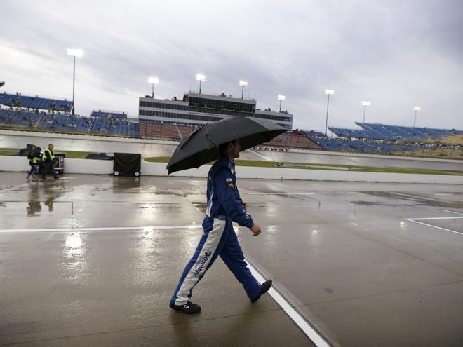 A crew member walks through the pit area during a rain delay at the Nationwide race Saturday at Iowa Speedway in Newton, Iowa.