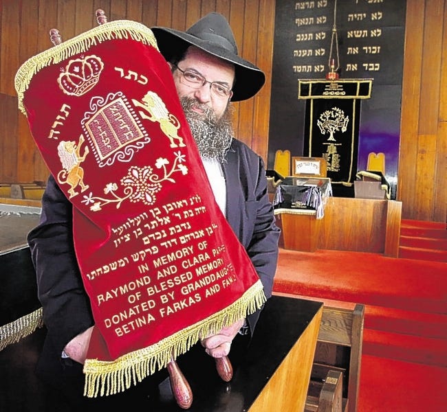Rabbi Ben-Zion Chanowitz proudly displays the new Torah at the Landfield Avenue Synagogue..