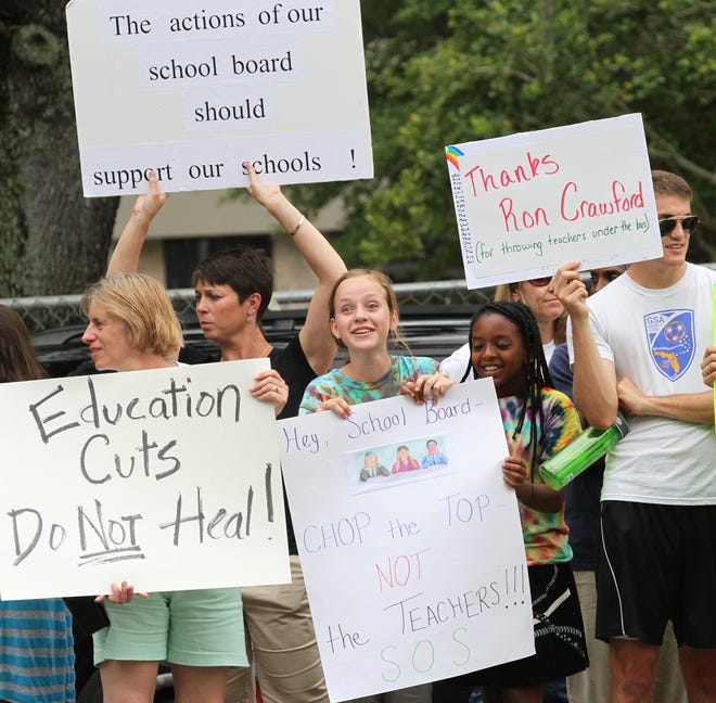 Hundreds of people hold signs as they protest with Save Our Schools (S.O.S.) on East Silver Springs Boulevard in Ocala on Wednesday.