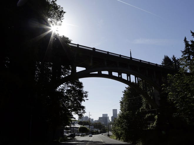 In this Tuesday, June 4, 2013, photo, downtown is visible under under the Vista Bridge, historically known as "The Suicide Bridge" , in the Goose Hollow neighborhood west of downtown Portland, Ore. The numbers vary annually, but a suicide or two occurs each year at the arch bridge from which there is a majestic vista of the city skyline. Now a group called Friends of the Vista Bridge is pressing the city to install suicide-prevention barriers, a step taken at bridges throughout the world where suicides have become prevalent. (AP Photo/Don Ryan)