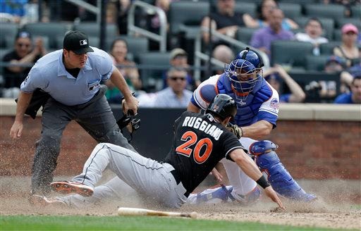 Home plate umpire Dan Bellino, left, watches as Mets catcher Anthony Recker, right, applies a late tag on Miami Marlins' Justin Ruggiano (20) in the 10th inning in New York, Sunday, June 9, 2013. The Marlins won 8-4.