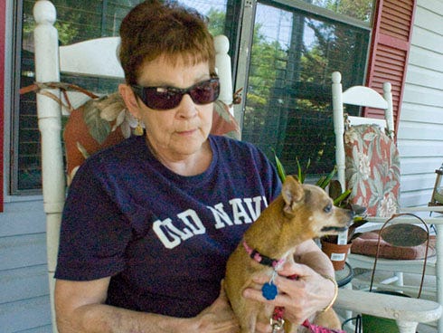 Barbara Barton relaxes with her latest rescue dog, Princess, on the porch of her Crestview home.