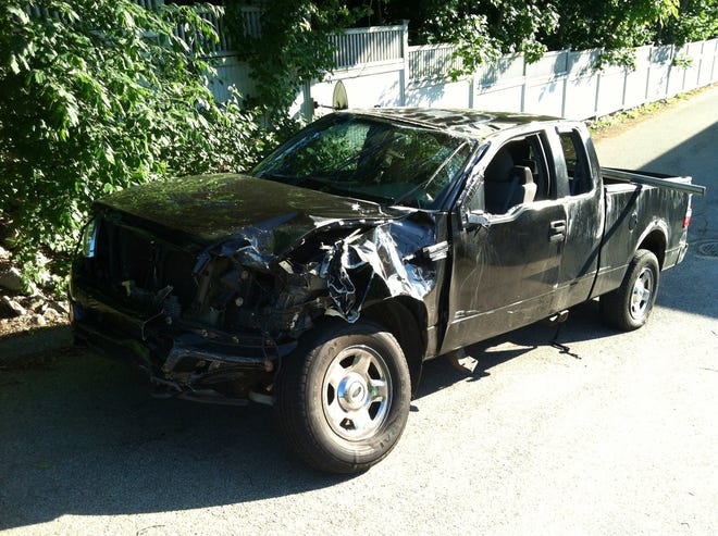 Police say a man driving this pickup disappeared into the woods off of Route 3 after nearly running over a police officer and crashing into a minivan.