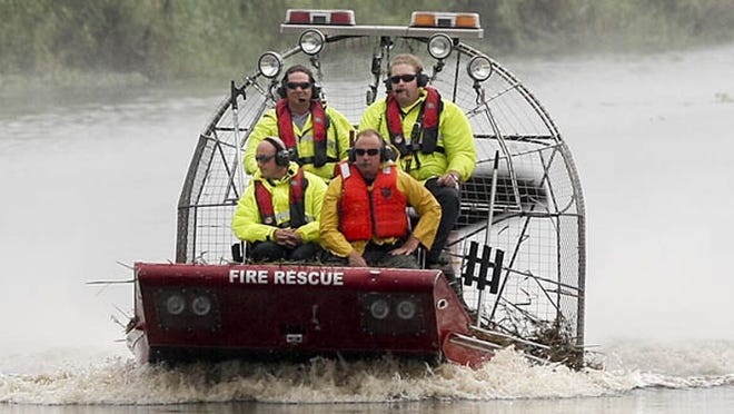 Three Palm Beach County fire rescue workers and one sheriff's deputy return to the boat launch area at 20 mile bend after investigating the site of small plane crash in Loxahatchee National Wildlife refuge Saturday, June 8, 2013. Curtis Rice, District Chief, Palm Beach County Rescue, said that fire rescue launced their airboat at 2:26 pm after learning about the crash from the coast guard. (Damon Higgins/The Palm Beach Post)