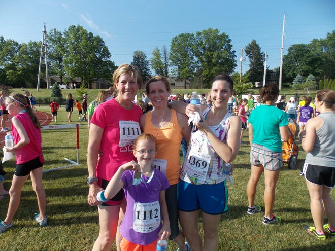 Elena Rowley (center, front) raced with her mom Chris Rowley (left) and friends Barb Matronia (center, standing) and Anne Watkins during the Girls on the Run 5-K race at Walsh University.