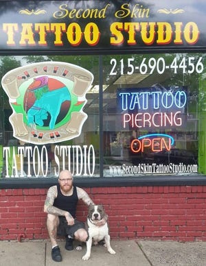 Orion "Twist" Myers sits outside his shop on Easton Road in Abington. This is one of six shops that will participate in a tattoo fundraiser for animals.