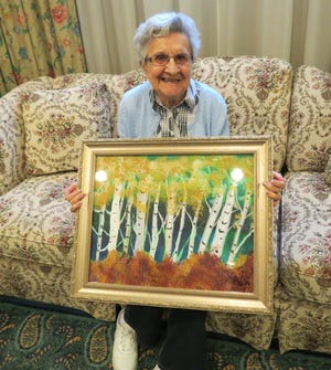 Pearl Neveux shows off one of her paintings that will be displayed in the art show at Atria Draper Place this week.