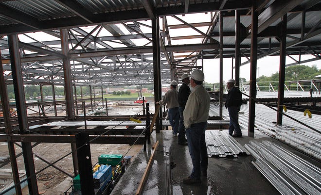 Members of the Franklin School Building Committee, A13 Architects, and Daedalus Projects, Inc., tour the construction site of the new high school Monday evening.