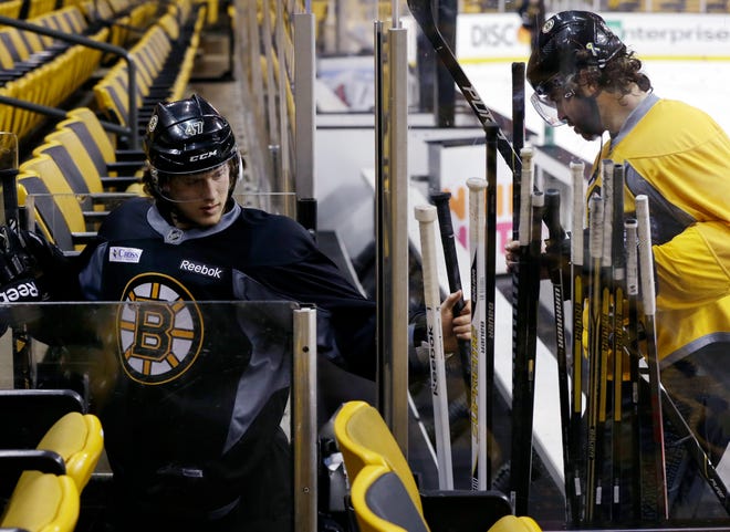 Boston Bruins defenseman Torey Krug, left, grabs a stick as he and Jaromir Jagr leave the ice after practice at TD Garden in Boston, Monday, June 10, 2013. The Bruins are preparing to face the Chicago Blackhawks in the NHL Stanley Cup finals with Game 1 scheduled for Wednesday in Chicago.