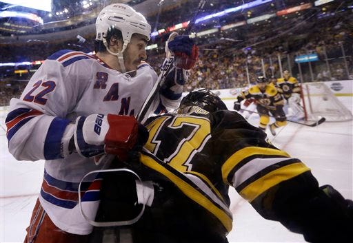 New York Rangers center Brian Boyle (22) grapples with Boston Bruins defenseman Torey Krug (47) along the boards during the third period in Game 2 of the NHL Eastern Conference semifinal hockey playoff series in Boston Sunday, May 19, 2013. The Bruins won 5-2. (AP Photo/Elise Amendola)