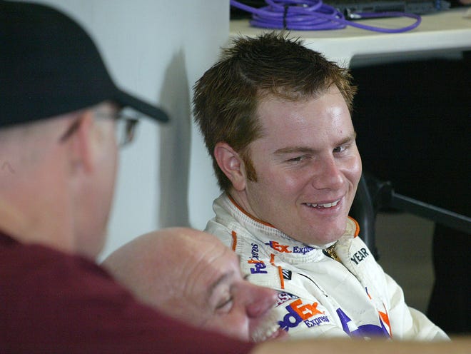 Jason Leffler talks with crew members in the garage area of Daytona International Speedway on Jan. 13, 2005.