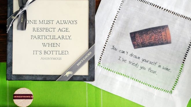 Joy of Palm Beach carries cocktail and wine accessories, including, clockwise from bottom, rolls of lime-green tear-off cloth cocktail napkins; glass wine straws; and two styles of cocktail napkins emblazoned with statements.