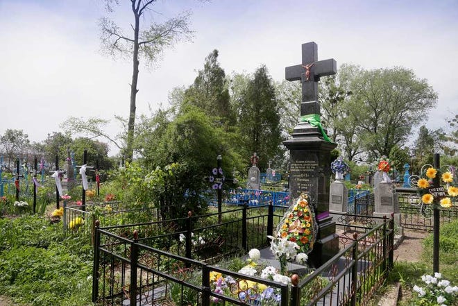 In this picture taken May 10, 2013, a monument pays tribute to civilians who were burned alive during WWII in Pidhaitsi close to Ukraine's western city of Lutsk. The monument reads: "To our parents, wives, children, who were murdered by the German occupants on December 3, 1943 in Pidhaitsi. 21 people, including 9 children." Evidence uncovered by AP indicates that Ukrainian Self Defense Legion commander Michael Karkoc's unit was in the area at the time of the massacre. (AP Photo/Efrem Lukatsky)