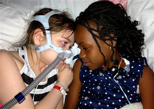 In this May 30, 2013 photo provided by the Murnaghan family, Sarah Murnaghan, left, lies in her hospital bed next to adopted sister Ella on the 100th day of her stay in Children's Hospital of Philadelphia. The 10-year-old suburban Philadelphia girl has been hospitalized at Children's Hospital of Philadelphia for three months with end-stage cystic fibrosis. Her family wants an exception made for Sarah to get an adult lung, because so few pediatric lungs become available. Kathleen Sebelius, U.S. Secretary of Health and Human Services, says she doesn't want to intervene in transplant decisions when other children are just as sick. Sarah's relatives say they want the policy changed for all children awaiting a lung transplant, not just Sarah. (AP Photo/Murnaghan family)