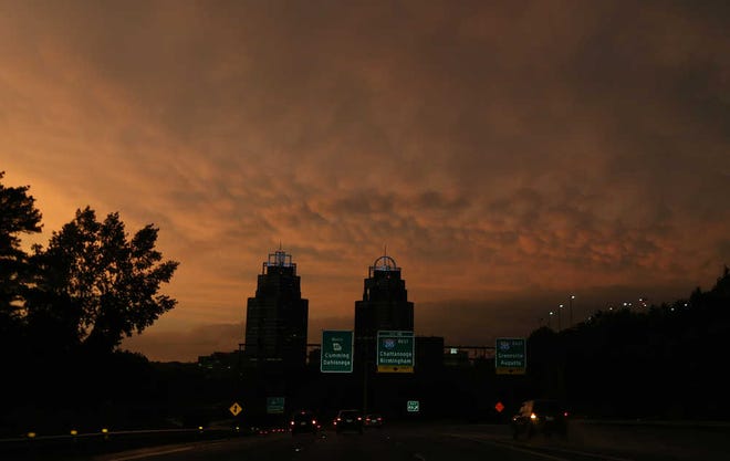 Post-storm clouds catch the setting sun above the King and Queen building in Sandy Springs on Thursday evening June 13, 2013. (AP Photo/The Atlanta Journal-Constitution, Ben Gray)