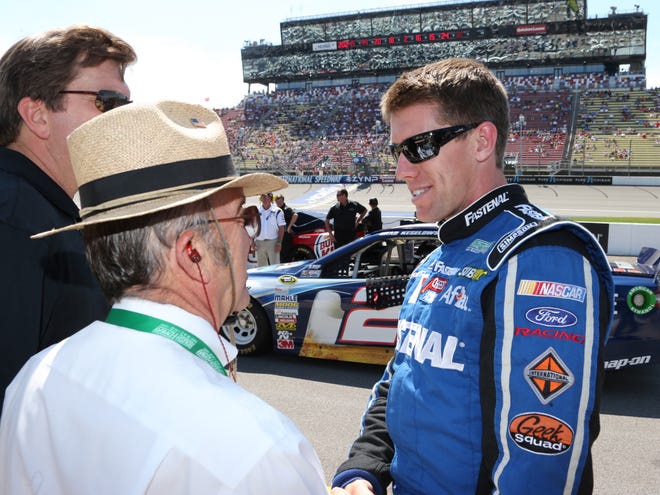 Driver Carl Edwards talks with owner Jack Roush after qualifying for Sunday's NASCAR Sprint Cup race at Michigan International Speedway on Friday. Edwards won the pole with a speed of 202.452 mph.