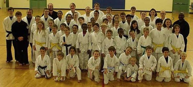 Students and instructors of Shinsei karate from Hartley, Palencia and South Woods Elementary schools at a recent promotion ceremony. Allie Bordley stands proudly in the back row, right (in black attire). Contributed photo.
