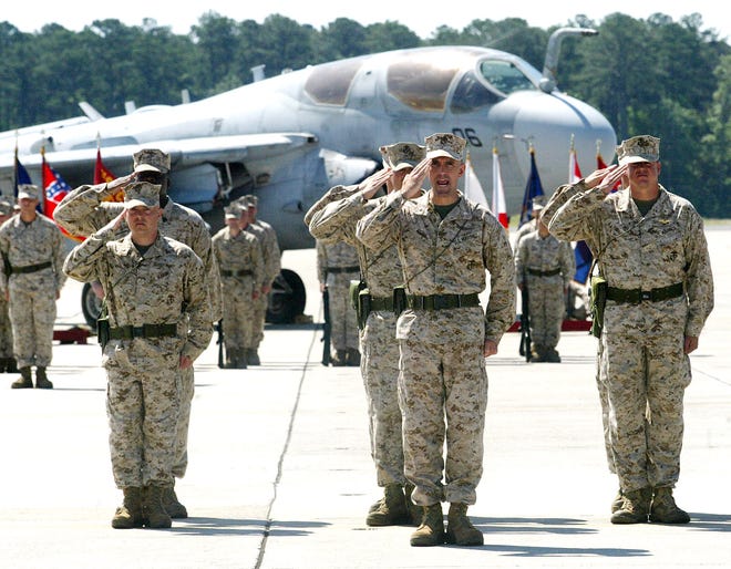 Marines salute in front of an EA-6B Prowler Friday at Cherry Point. The Marines were participating in a ceremony as Marine Tactical Electronic Warfare Squadron 1 was redesignated to Marine Tactical Electronic Warfare Training Squadron 1.
