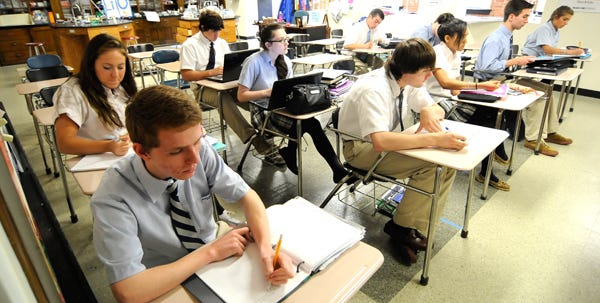 Students attend a chemistry class at Pope John Paul II High School on Friday. Th Catholic Diocese of Fall River announced that the high school will merge with neighboring St. Francis Xavier Preparatory School.