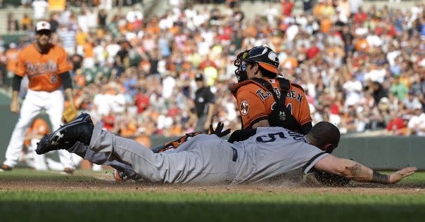 Jonny Gomes slides past Baltimore's Orioles catcher Taylor Teagarden for a run on a double by Stephen Drew in the fourth inning of Saturday's game. The Red Sox were 5-4 winners.