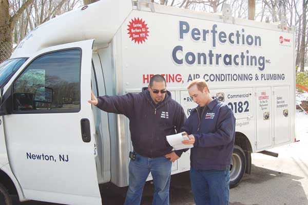 Antonio Poccio, right, owner of Perfection Contracting, discusses a job with his service manager, Matt Mastrolacasa.
