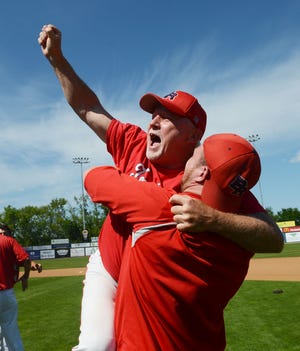 Bridgewater-Raynham head coach John Kearney is hoisted into the air by one of his players during the celebration following the Trojans' 4-0 win over Nashoba on Saturday in the Division 1 state championship game.