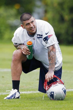 New England Patriots' Aaron Hernandez kneels on the field during NFL football practice in Foxborough, Mass., Wednesday, May 29, 2013. (AP Photo/Michael Dwyer)