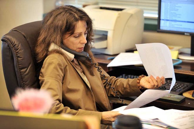 General Counsel Cindy Laquidara takes a phone call while going through paperwork in her City Hall office in 2010 when she was first apponted by then Mayor John Peyton.