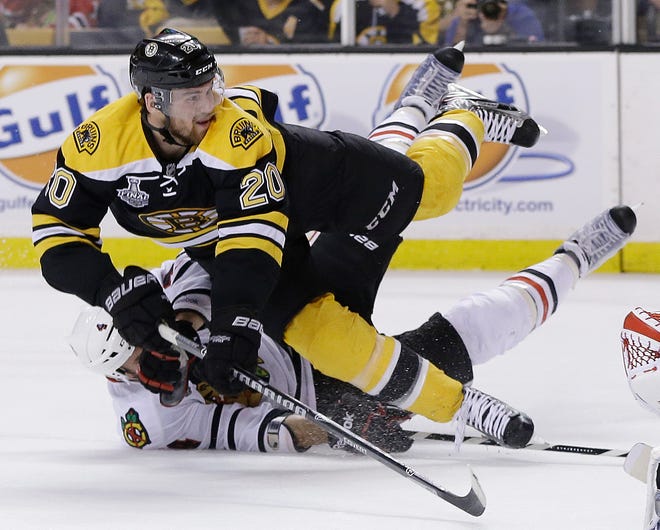 Chicago Blackhawks defenseman Niklas Hjalmarsson, bottom, takes down Boston Bruins left wing Daniel Paille during the second period in Game 3 of the NHL Stanley Cup finals in Boston, Monday, June 17, 2013. The Bruins scored the game's second goal on the power play that followed.
