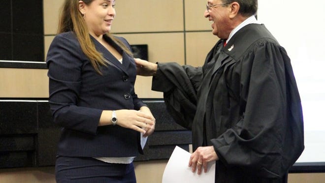 Judge Ronald Alvarez congratulates Veronica Limia after he swore her in as an attorney in his courtroom at the Palm Beach County Courthouse juvenile division on Monday afternoon. Alvarez had once sentenced Limia to the Florida Institute for Girls, but the troubled teen turned her life around with help from the judge and her mother and counselor.