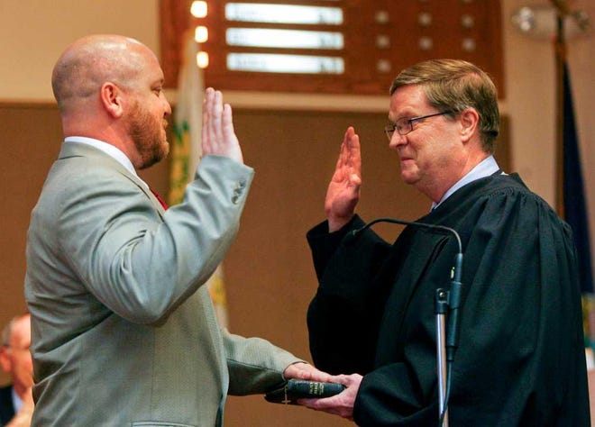 Municipal Court Administrative Judge Vic Miller swears in new District 8 Topeka City Council member Nathan Schmidt after the governing body interviewed him and two other candidates Tuesday night.