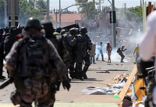Riot police clash with protesters near the Castelao stadium in Fortaleza, Brazil, Wednesday. Protesters cut off the main access road to the stadium where Brazil will play Mexico in the Confederations Cup soccer tournament later Wednesday. Beginning as protests against bus fare hikes, the demonstrations have quickly ballooned to include broad middle-class outrage over the failure of governments to provide basic services and ensure public safety.