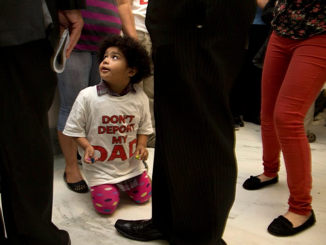 Jackelin Alfaro, 4, wears a T-shirt that reads "Don't Deport my Dad" and sits in the hall with family members outside the House Judiciary Committee hearing on Capitol Hill in Washington on Tuesday.