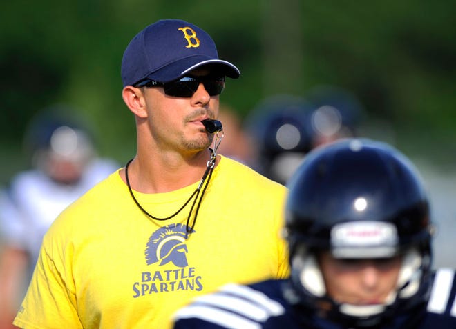 Battle football Coach Justin Conyers watches over a summer workout Wednesday at the high school. Conyers said he had about 80 potential players arrive for tryouts for the first-year Spartans.