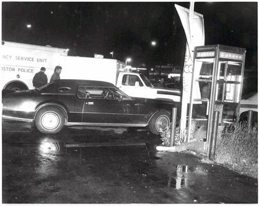 This undated black and white photo released by the U.S. Attorney's Office and presented as evidence Wednesday, June 19, 2013, during the trial of James "Whitey" Bulger in U.S. District Court in Boston, shows a crime scene where a victim was shot to death in a telephone booth. Bulger, the reputed former head of the mostly Irish-American Winter Hill Gang based in South Boston, is accused of playing a role in 19 killings during the 1970s and '80s. (AP Photo/U.S. Attorney's Office)